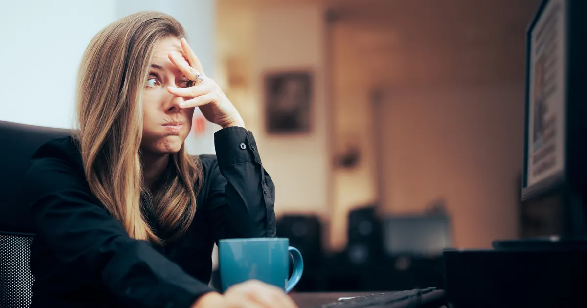 Woman sitting at desk with an embarrassed look on her face