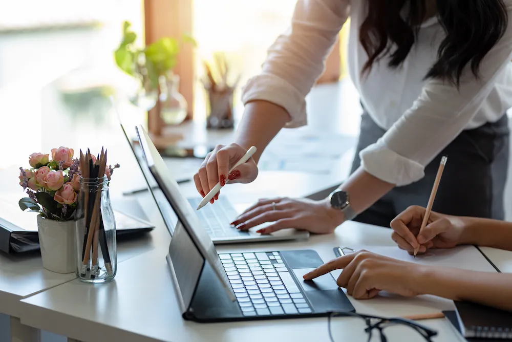 Two web designers at a desk discussing a design project