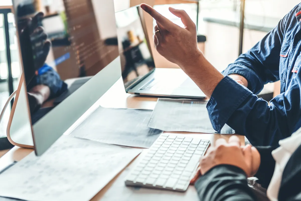 Two web designers at a desk reviewing a website design project
