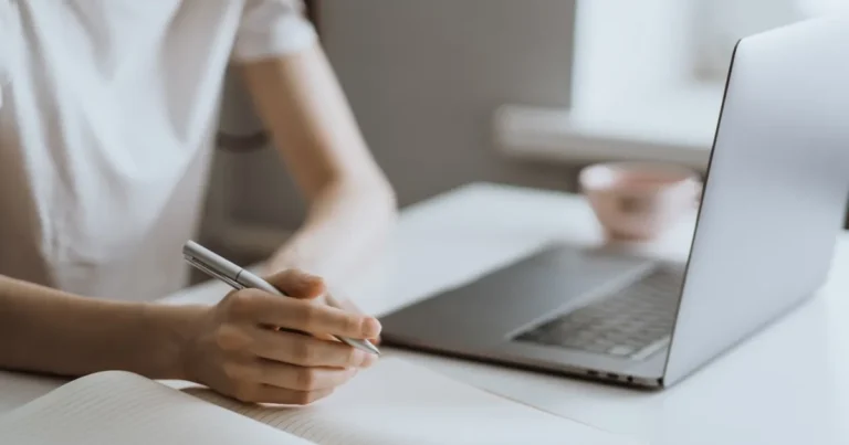 Woman at desk with laptop and notepad